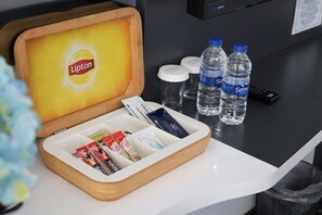 A hotel minibar with Lipton tea, Sirmi water bottles, and assorted snacks. - Cavit Duvan Prestige Hotel (Edirne)