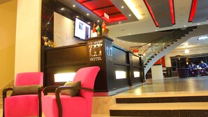 A hotel reception area with a modern design, featuring a reception desk, a staircase, and seating areas. - Abu Mazen Hotel (Hebron)