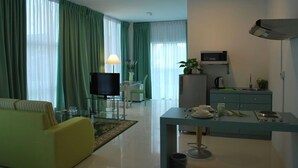 Una sala de estar moderna con un sofá, un televisor y un comedor con mesa y sillas.