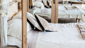Een kamer met een bed, een houten deur en een raam.