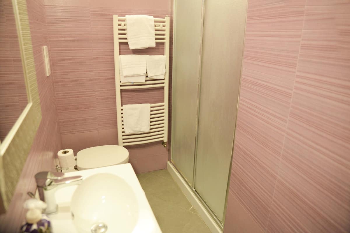 Une salle de bain équipée de toilettes, d’un lavabo et d’un porte-serviettes avec plusieurs serviettes.