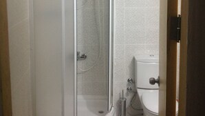 A bathroom with a glass-enclosed shower, a toilet, and a wall-mounted water heater. - Öz Mert Hotel (Konyaalti)