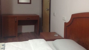 A hotel room with a wooden desk, a bedside table, a bed, and a mirror on the wall. - Öz Mert Hotel (Konyaalti)