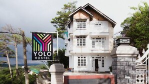 Un edificio de dos pisos con un letrero que dice Yolo Hostel.