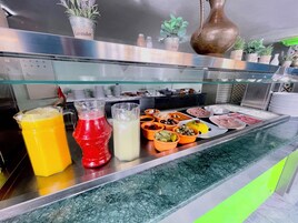 Un mostrador de buffet con diversos alimentos y bebidas.