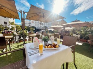An outdoor dining area with tables, umbrellas, and a view of a historic building. - Royal Victoria - Ex British Embassy (Tunis)