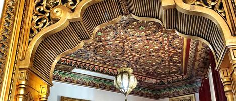 Een versierde architecturale detail met ingewikkelde houtsnijwerken en een kroonluchter.