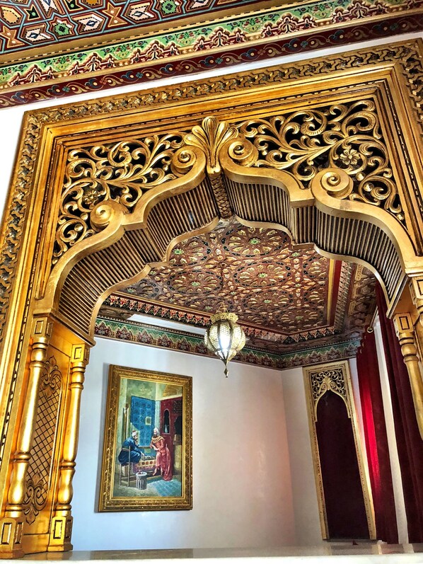 An ornate architectural detail with intricate carvings and a chandelier. - Royal Victoria - Ex British Embassy (Tunis)