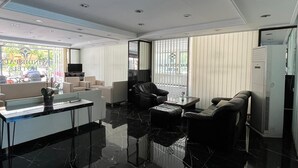 A modern hotel room with a glass coffee table, black leather sofa, and a large window with blinds. - Bayindir Palme (Antalya)