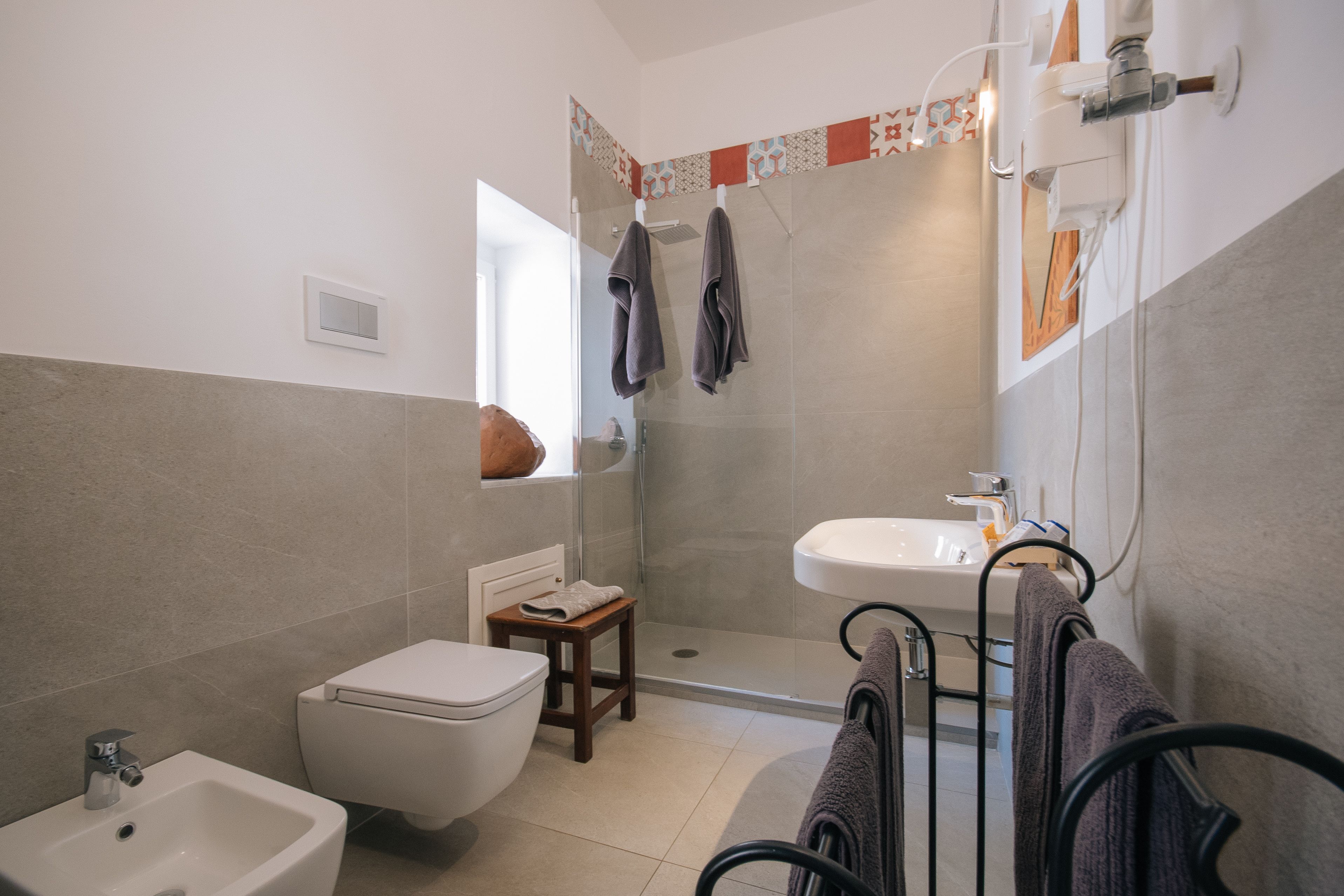 Ein modernes Badezimmer mit Toilette, Bidet, Waschbecken und Dusche.