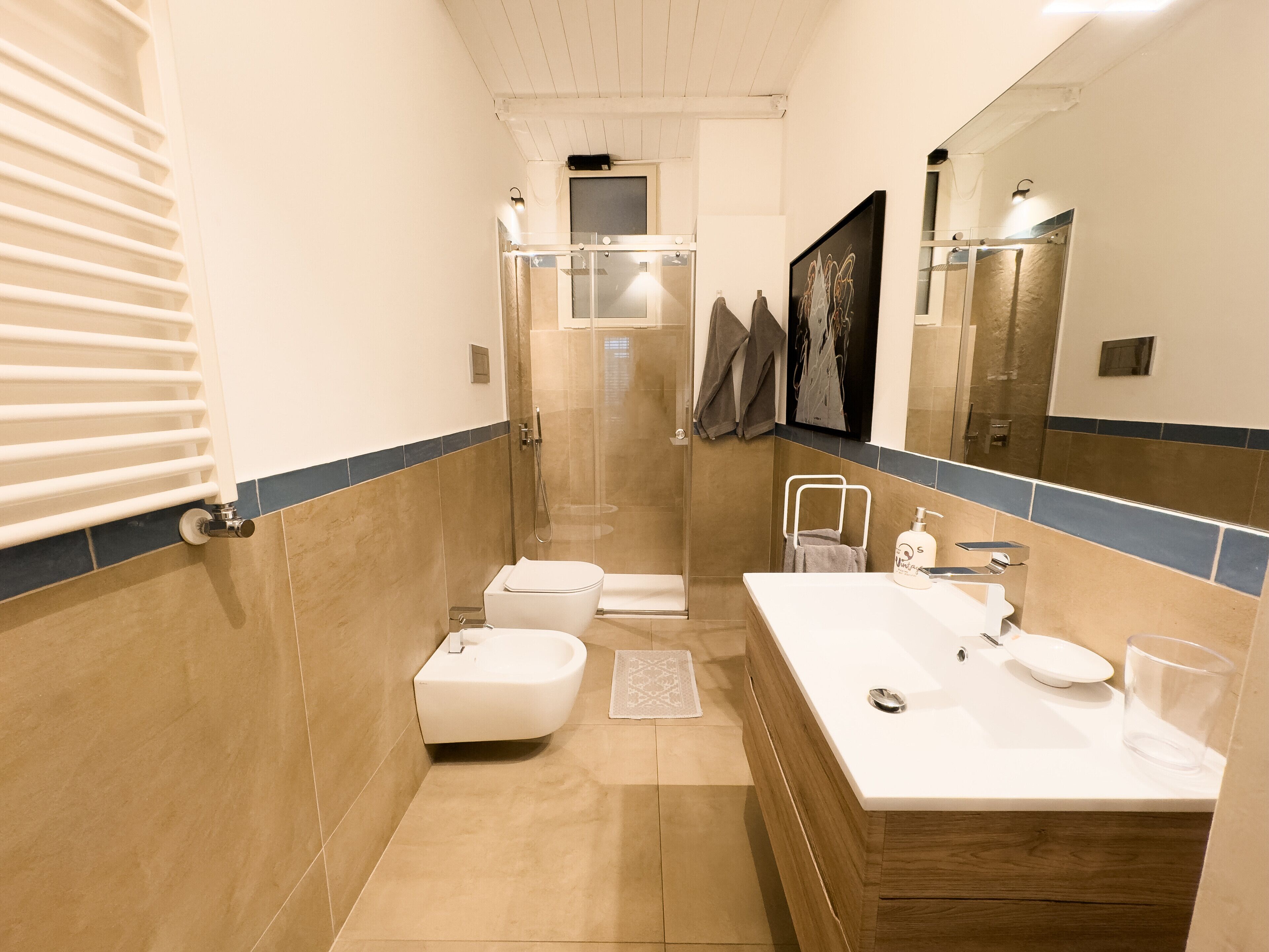 A modern bathroom with a shower, toilet, and sink.