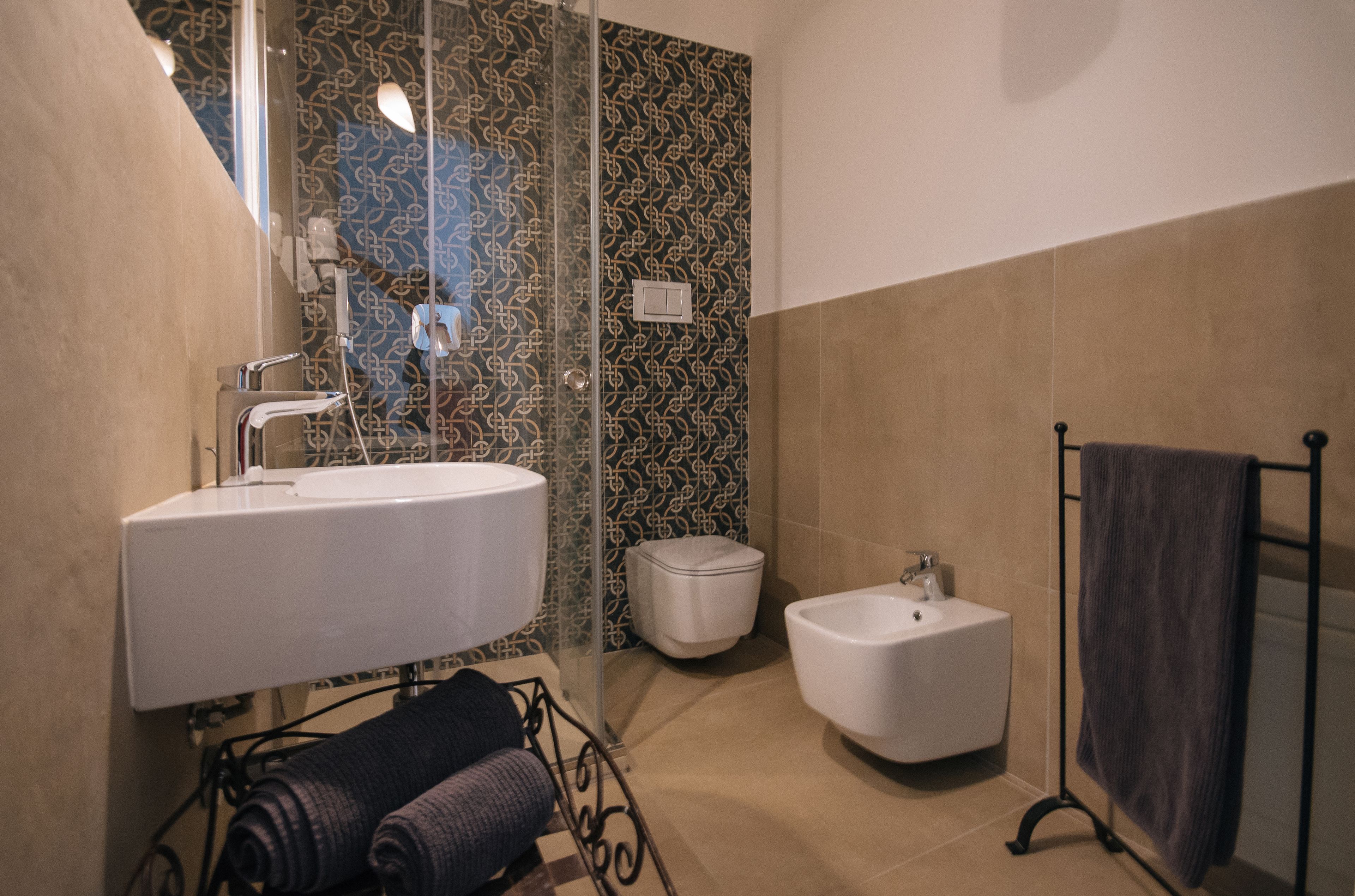 Un bagno moderno con un lavandino grande, un bidet e un box doccia in vetro.