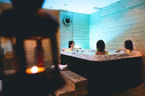 A wooden interior with a hot tub, wooden benches, and a wall clock. - Hôtel Le Loup Blanc (Uvernet-Fours)