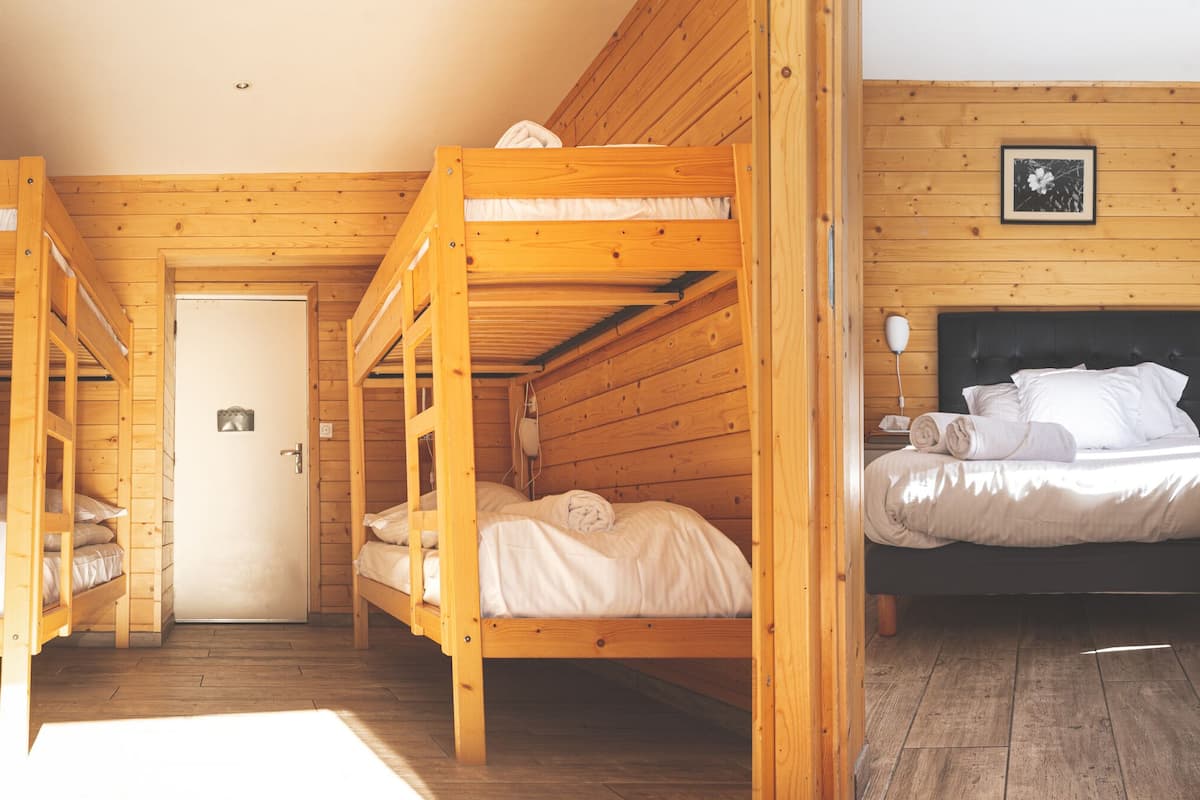 A wooden cabin with bunk beds and a single bed.
