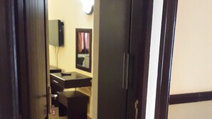 An open doorway leading to a kitchen area with a refrigerator, a microwave, and a sink. - Hotel Al-Khalil (Matola)