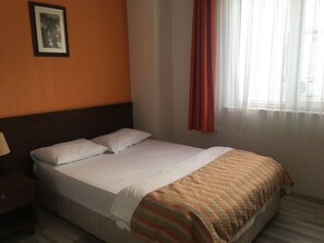 A hotel room with a bed, a nightstand, a framed picture on the wall, and a window with curtains. - Mutado Hotel (Antalya)