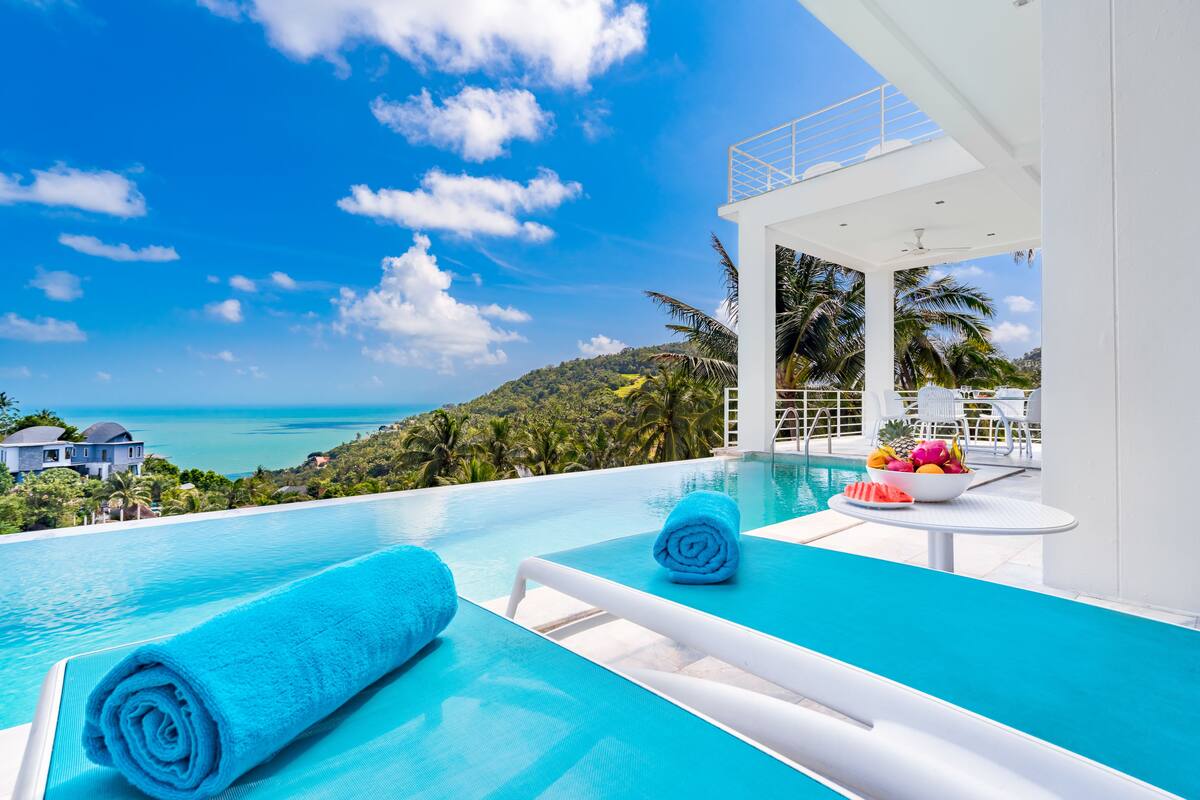 Una piscina infinita moderna con vistas al océano y un paisaje tropical.