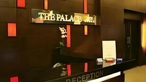 Un mostrador de recepción con un cartel que dice 'THE PALACE HOTEL'.