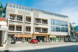 Un edificio de varios pisos con locales comerciales en la planta baja, incluyendo una boutique y una cafetería.