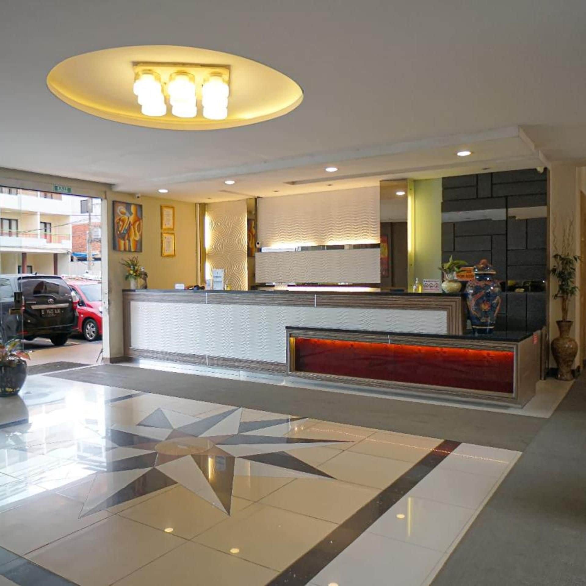 Ein Hotel-Empfangsbereich mit modernem Design, einer Rezeption und einem gefliesten Boden.