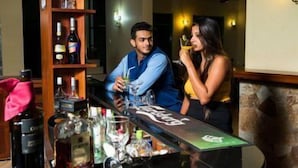 Een bar met een toonbank, flessen en glazen.
