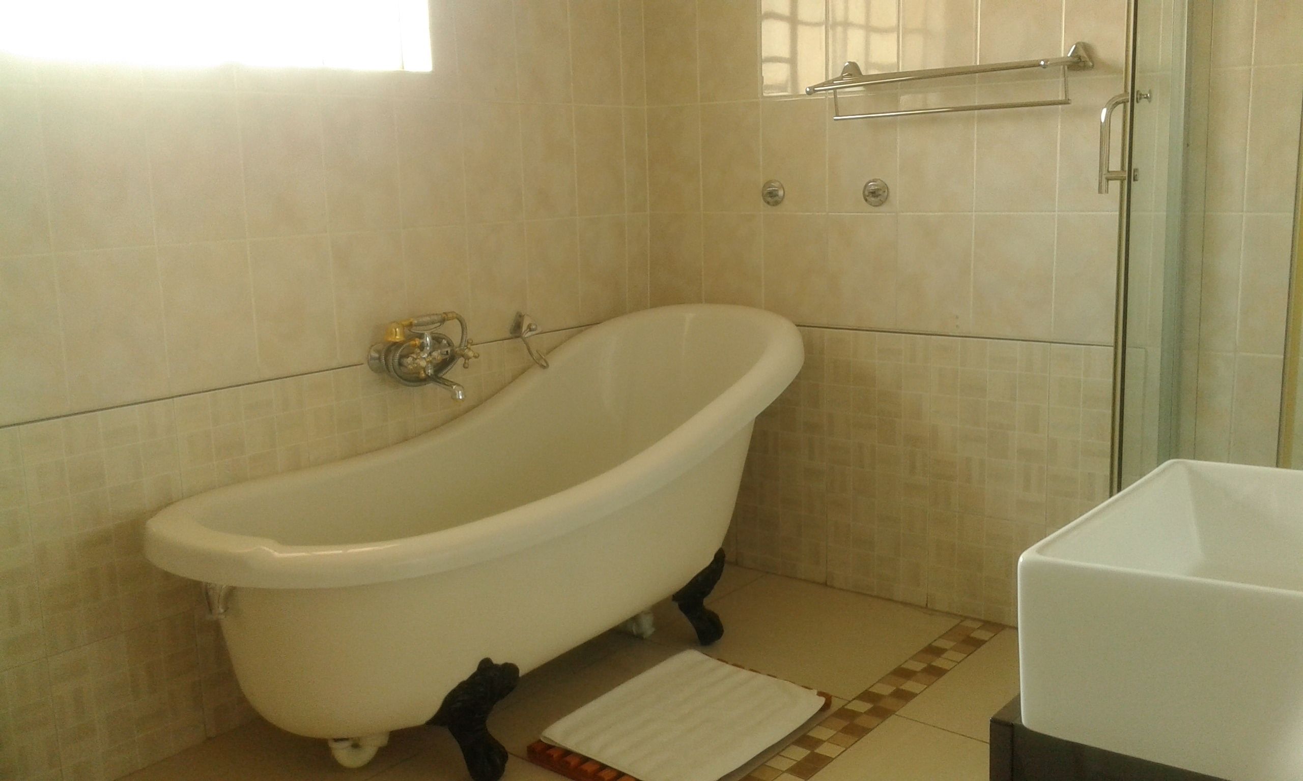 A bathroom with a freestanding bathtub, a glass shower enclosure, and a white sink.