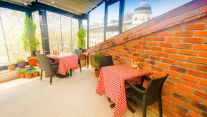 An outdoor patio with two tables and chairs, potted plants, and a view of a historic building. - Venue Hotel Old City Istanbul (Istanbul)
