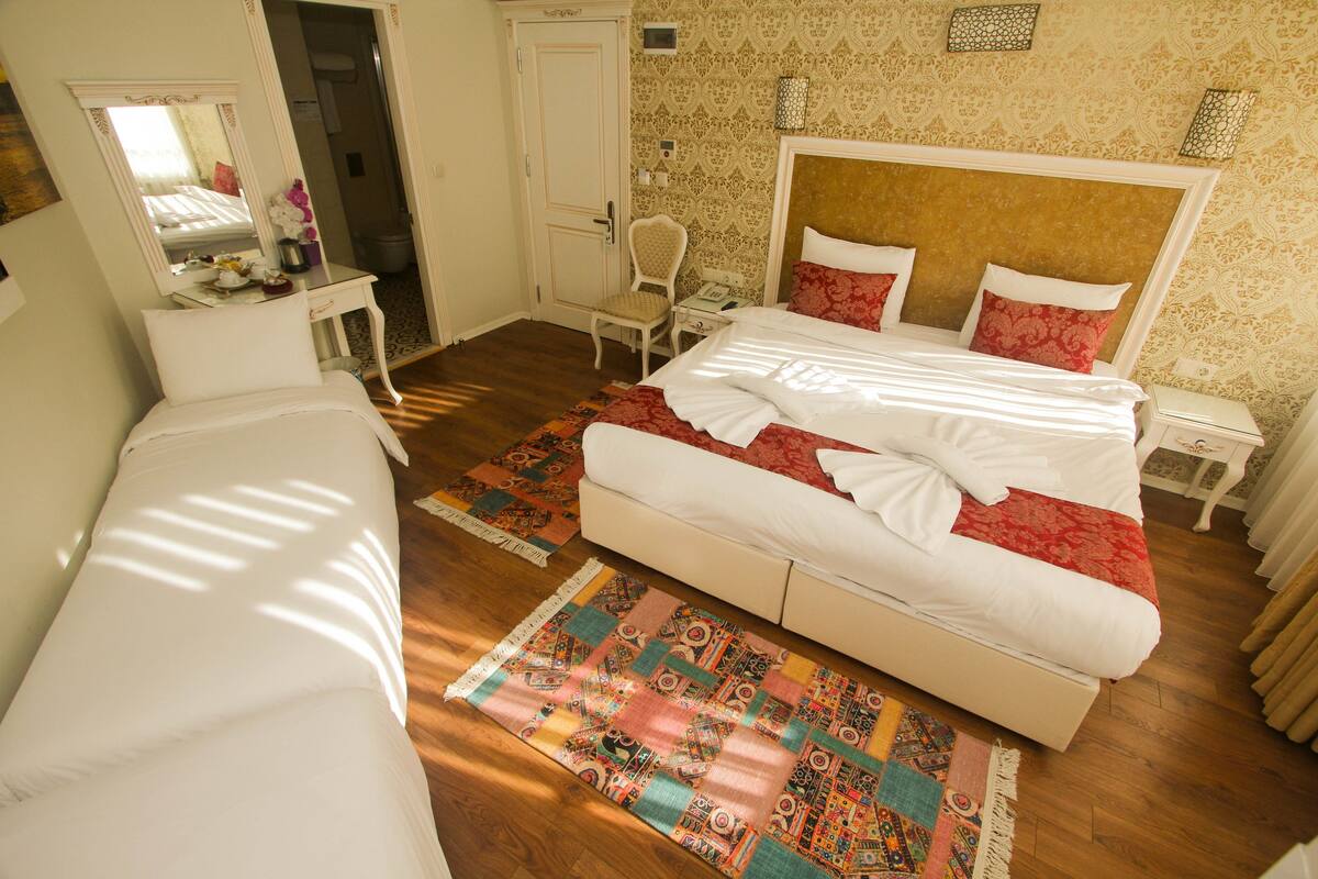 Een hotelkamer met twee bedden, een zithoek, een bureau en een badkamer.