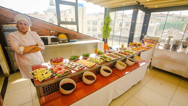 A buffet setup with various food items and a chef standing beside it. - Venue Hotel Old City Istanbul (Istanbul)
