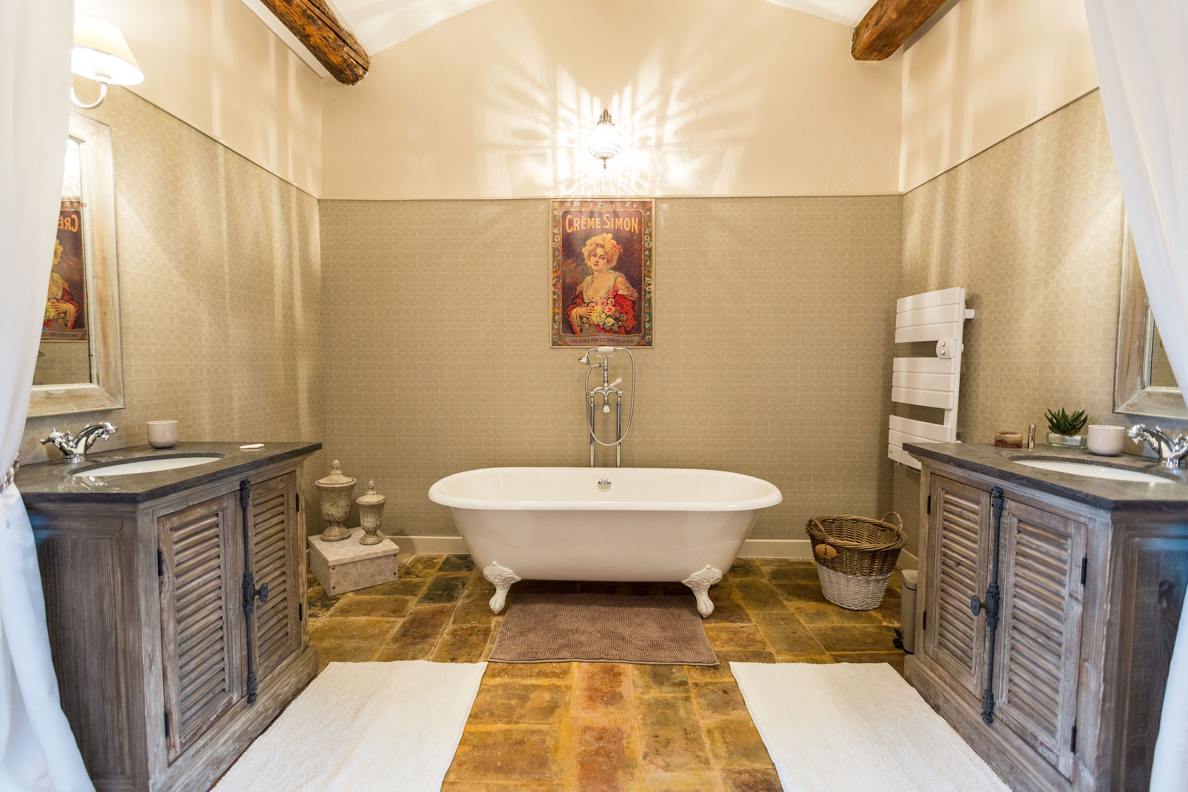 Un bagno con una vasca freestanding, due lavandini e un grande specchio.