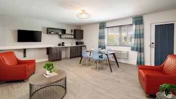 Suite Deluxe, 1 habitación | Área de sala de estar | Televisión de pantalla plana de 42 pulgadas con canales por cable