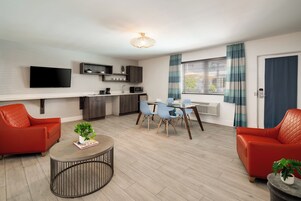 Deluxe One Bedroom Queen Suite | Living area | 42-inch flat-screen TV with cable channels, TV, iPod dock