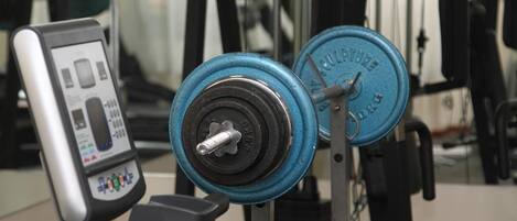 A weightlifting bench with a digital scale and a barbell with blue weight plates.