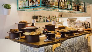 A bar area with a teal sign reading "No 24", shelves of bottles, and a variety of food items on display. - Santa Maria 24 - Luxury Apartments (Monopoli)
