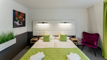 Una habitación de hotel con una cama grande, dos mesitas de noche, una lámpara de noche, una silla, un cuadro en la pared y una cortina verde.