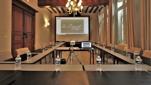 A conference room with a projector screen displaying "Le Régent Hotel" branding, a laptop, and water bottles on the tables. - Hotel Le Regent (Villers-Cotterets)