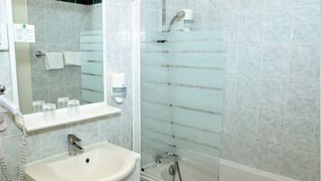 Un baño con lavamanos, espejo y ducha.