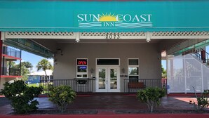 A hotel entrance with a sign reading "SUN COAST INN" and the number "2073". - Sun Coast Inn (Englewood)