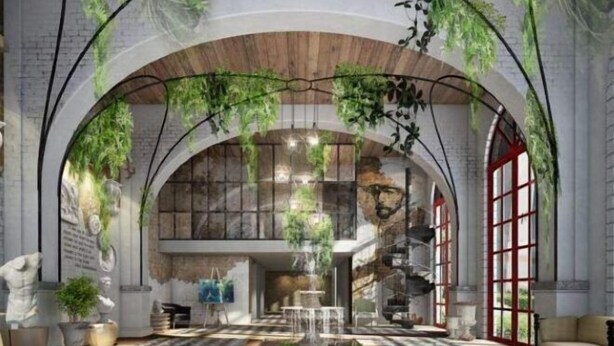 Interior con techo abovedado, plantas colgantes y una escalera central.
