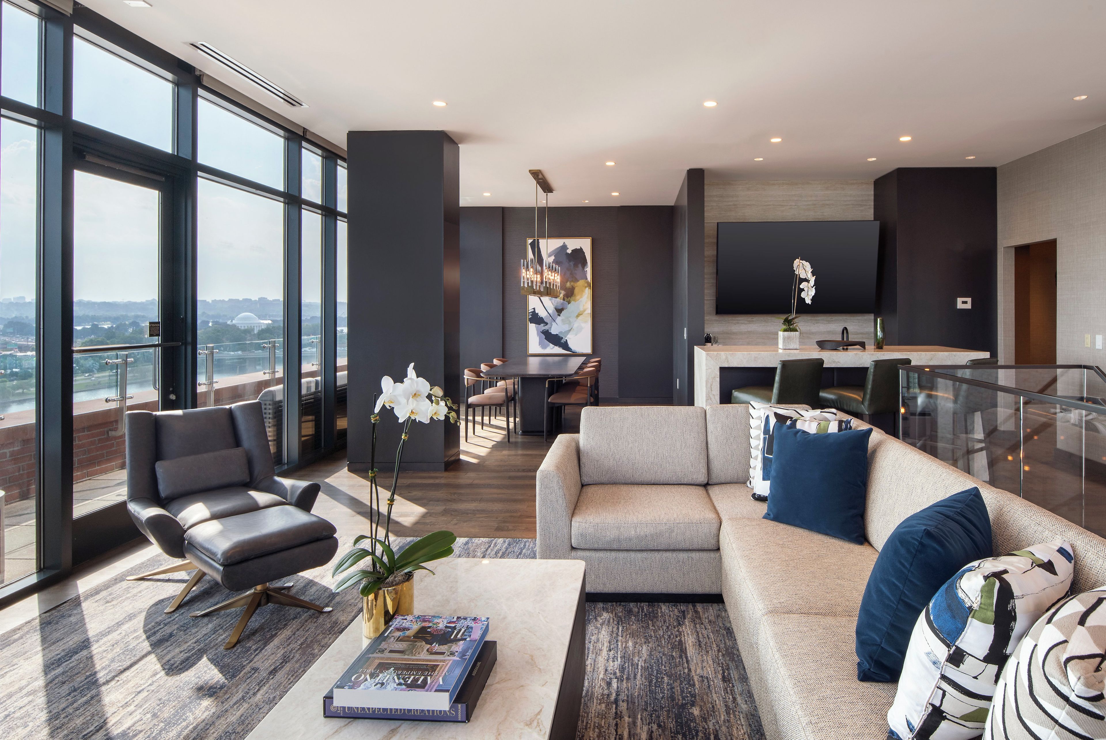 Een moderne woonkamer met een bank, fauteuil en salontafel met een boek.