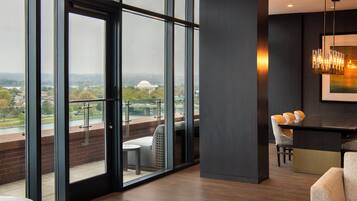 Un intérieur moderne avec de grandes fenêtres, un coin repas et une vue sur le paysage urbain.