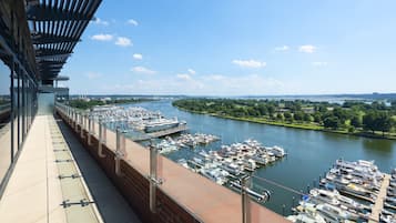 Een jachthaven met aangemeerde boten, een rivier en een brug met voetgangerspad.