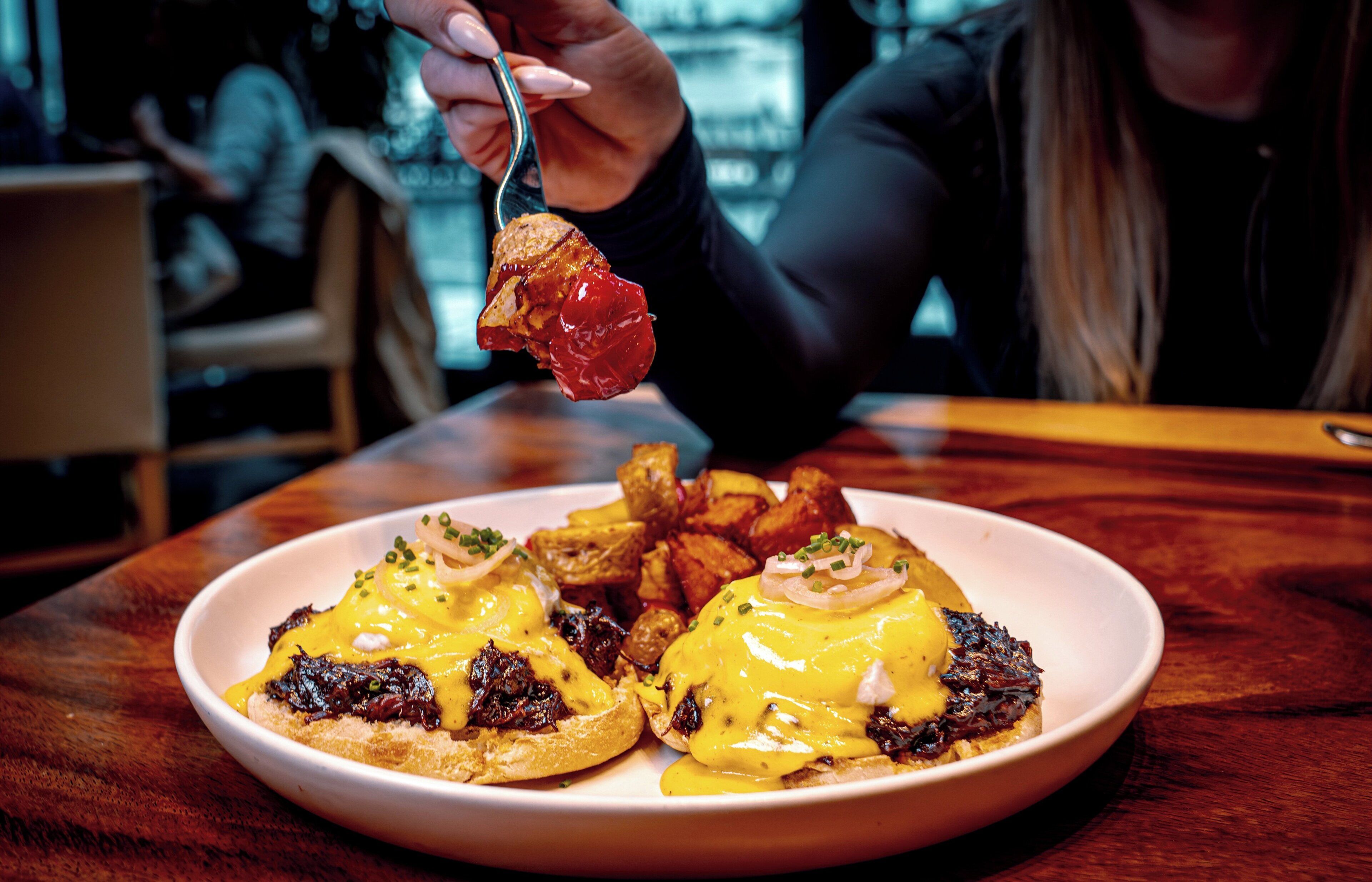 A plate of food with eggs benedict and fries.