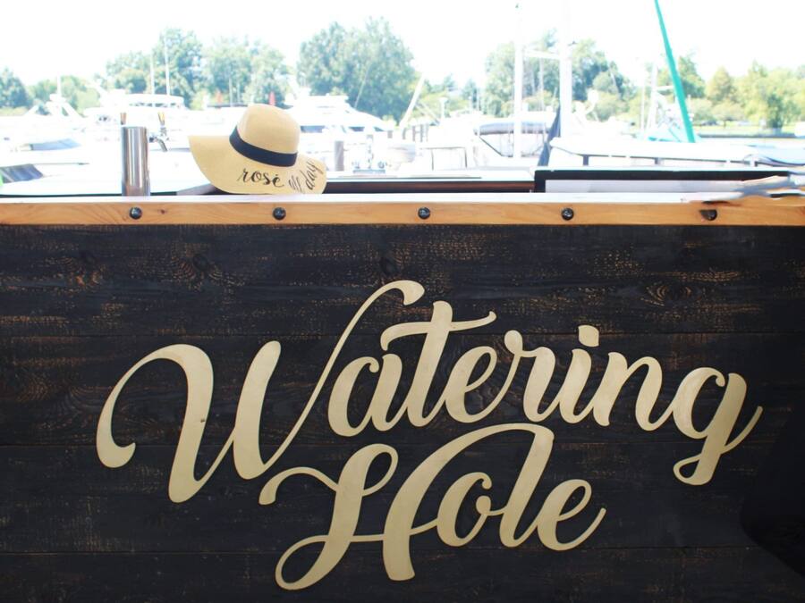 A wooden sign with the words 'Watering Hole' in cursive lettering.