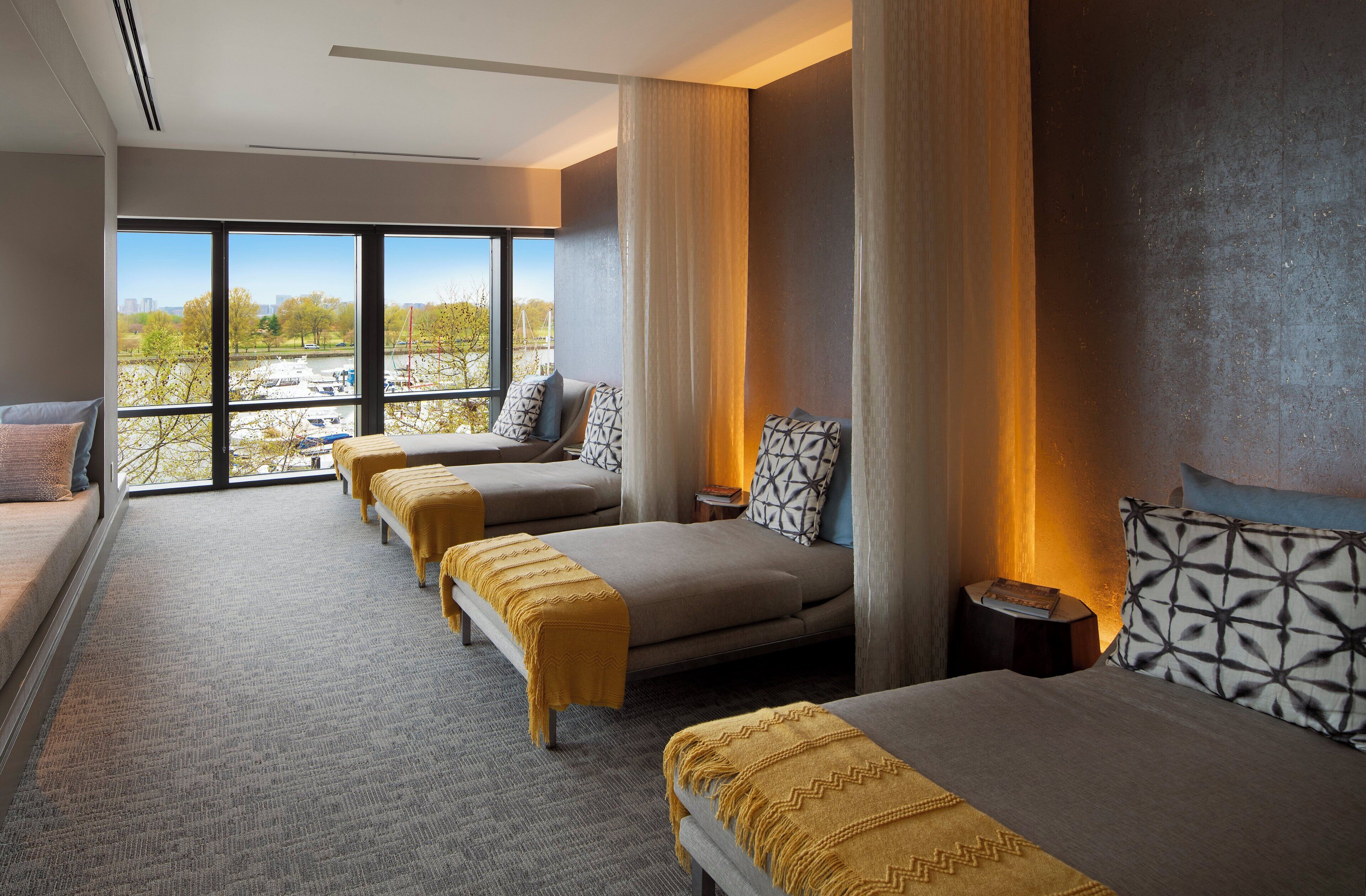 Ein Hotelzimmer mit großem Fenster, einer Couch, einem Bett und einem kleinen Tisch.
