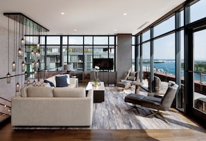 A spacious living area with a large window, a sofa, a coffee table, and a TV. - InterContinental Washington D.C. - The Wharf by IHG (Washington)