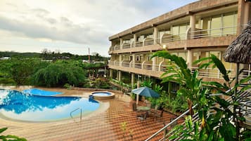 Relax by the pool surrounded by lush greenery and trees.