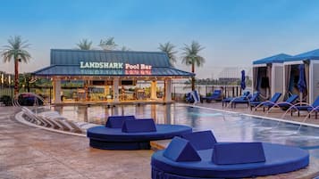 Zona de piscina con sillones de descanso y un bar junto a la piscina llamado "LANDSHARK Pool Bar".