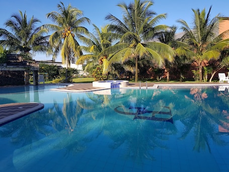 Una piscina al aire libre, sillones reclinables de piscina