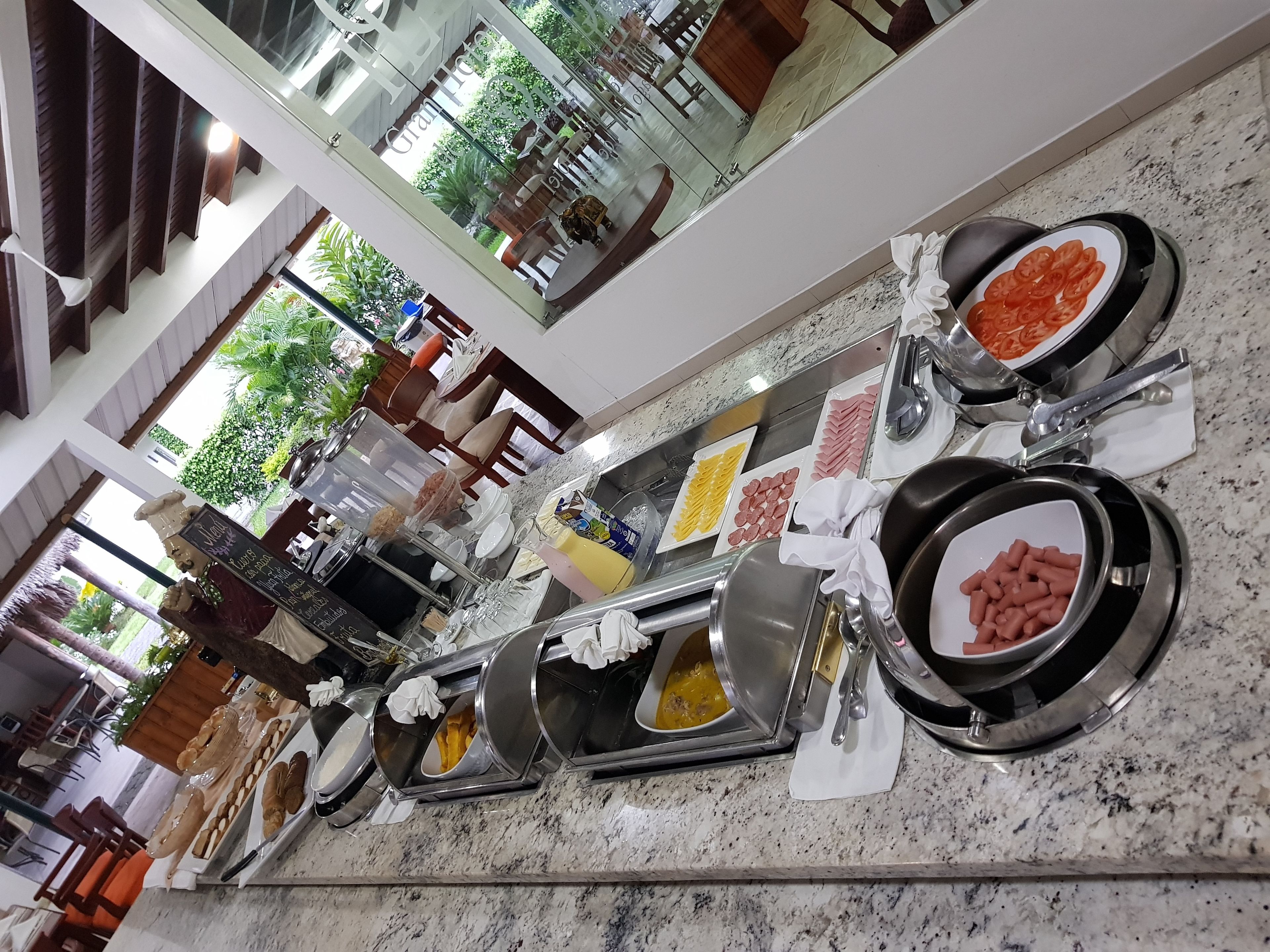 Una mesa de buffet con diversos alimentos, como carnes, quesos y pasteles, dispuestos sobre una encimera de mármol.
